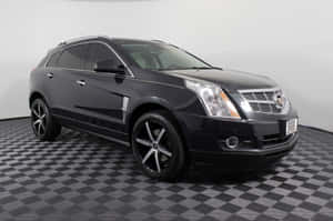 Sleek Cadillac Srx On The Road Wallpaper