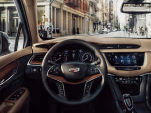 Sleek Cadillac Xt5 In Vibrant City Setting Wallpaper