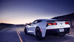 Sleek Chevrolet Corvette Grand Sport Cruising On The Highway Wallpaper