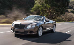 Sleek Convertible Car On Open Road Wallpaper