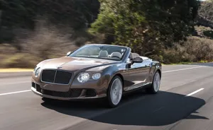 Sleek Convertible Car On Open Road Wallpaper