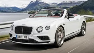 Sleek Convertible Sports Car On A Scenic Coastal Road Wallpaper