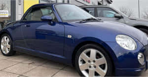 Sleek Daihatsu Copen Against Urban Backdrop Wallpaper