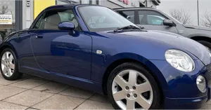 Sleek Daihatsu Copen Against Urban Backdrop Wallpaper