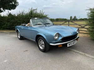 Sleek Fiat 124 Spider Cruising The Open Road Wallpaper
