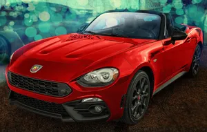 Sleek Fiat 124 Spider On Scenic Road Wallpaper