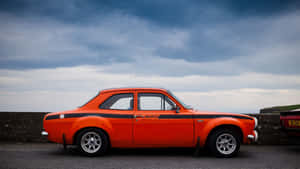 Sleek Ford Escort Cruising Down An Open Road Wallpaper