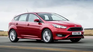 Sleek Ford Focus Cruising Through A City Landscape Wallpaper