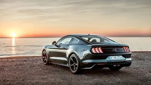 Sleek Ford Mustang Bullitt Cruising On A Scenic Road Wallpaper