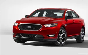 Sleek Ford Taurus Cruising On The Highway Wallpaper