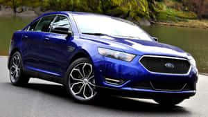 Sleek Ford Taurus Cruising On The Road Wallpaper