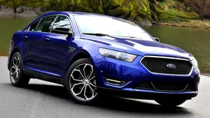 Sleek Ford Taurus Cruising On The Road Wallpaper