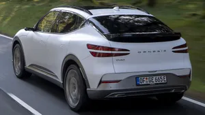 Sleek Genesis Gv60 Electric Suv Cruising On The Highway Wallpaper