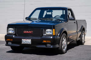 Sleek Gmc Syclone Parked In Dramatic Urban Setting Wallpaper