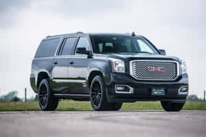 Sleek Gmc Yukon Suv On The Road Wallpaper