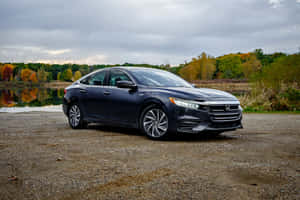 Sleek Honda Insight Parked On A Rooftop At Sunset Wallpaper