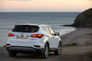 Sleek Hyundai Santa Fe Driving Through A Scenic Landscape Wallpaper