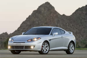 Sleek Hyundai Tiburon Racing On An Open Road Wallpaper