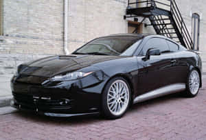 Sleek Hyundai Tiburon Sports Coupe Against Scenic Background Wallpaper