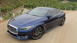 Sleek Infiniti Q60 Sports Coupe In Scenic Road Trip Wallpaper