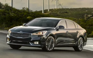 Sleek Kia Cadenza Cruising On A Scenic Highway Wallpaper