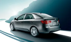 Sleek Kia Forte Sedan Cruising On The Road Wallpaper