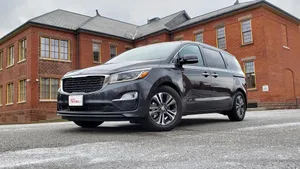 Sleek Kia Sedona In A Beautiful Cityscape Wallpaper