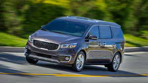 Sleek Kia Sedona Minivan On The Road Wallpaper