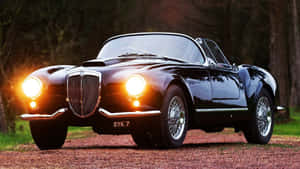 Sleek Lancia Classic On A Scenic Drive Wallpaper