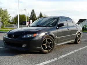 Sleek Mazda Protege Cruising On The Open Road. Wallpaper