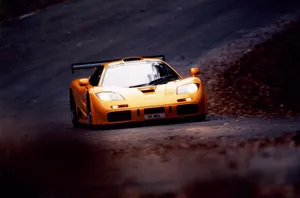 Sleek Mclaren F1 Racing On An Open Road Wallpaper