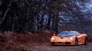 Sleek Mclaren F1 Speeding On A Racing Track Wallpaper