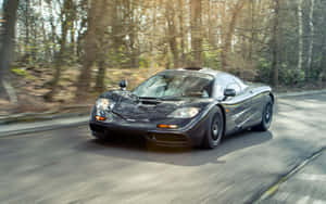 Sleek Mclaren F1 Speeding On The Road Wallpaper