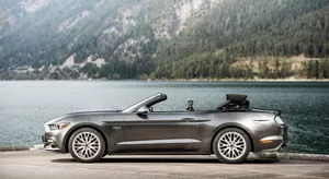 Sleek Midnight Blue Ford Mustang Gt Convertible In Urban Landscape Wallpaper