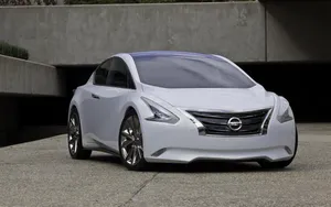 Sleek Nissan Altima Driving On A Scenic Road Wallpaper