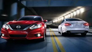 Sleek Nissan Altima Driving On The Open Road Wallpaper