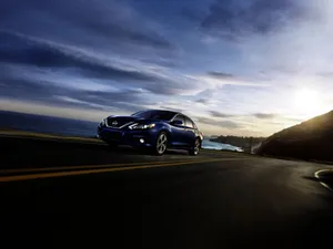 Sleek Nissan Altima On Open Road Wallpaper