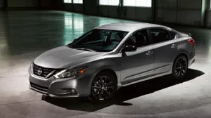 Sleek Nissan Altima Showcasing Its Dynamic Design On The Road Wallpaper