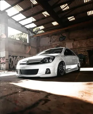 Sleek Opel Astra In Motion On A Picturesque Road Wallpaper