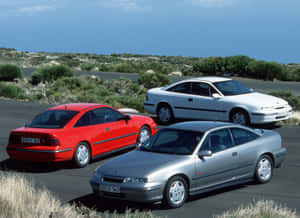 Sleek Opel Calibra Cruising On The Highway Wallpaper