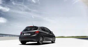 Sleek Peugeot 208 Gliding Effortlessly On A Winding Road Wallpaper