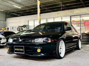 Sleek Proton Wira In Motion On A Smooth Highway Wallpaper