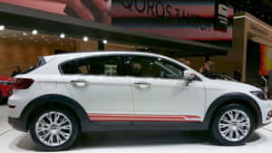 Sleek Qoros Car On Urban Road Wallpaper