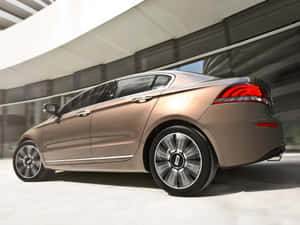 Sleek Qoros Sedan Driving On A Winding Road Wallpaper