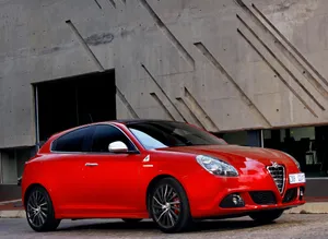 Sleek Red Alfa Romeo Giulietta In Action Wallpaper