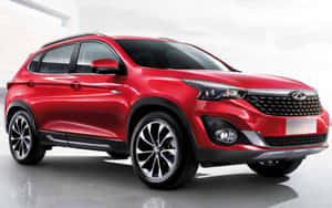 Sleek Red Chery Car On A Scenic Road Wallpaper