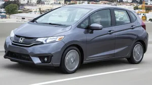 Sleek Red Compact Car In Urban Setting Wallpaper