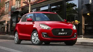 Sleek Red Compact Car Parked On The Street Wallpaper