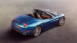 Sleek Red Ferrari California T On A Scenic Road Wallpaper