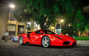 Sleek Red Ferrari Enzo In Motion Wallpaper